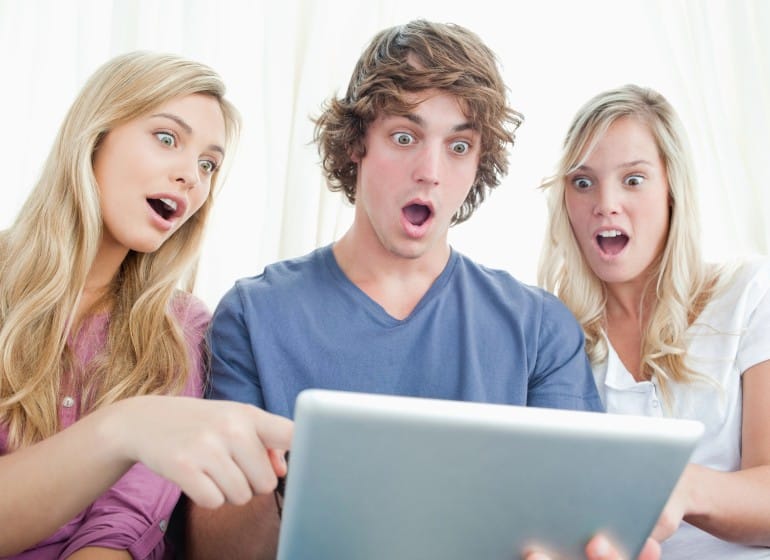 Employees looking surprised at a computer