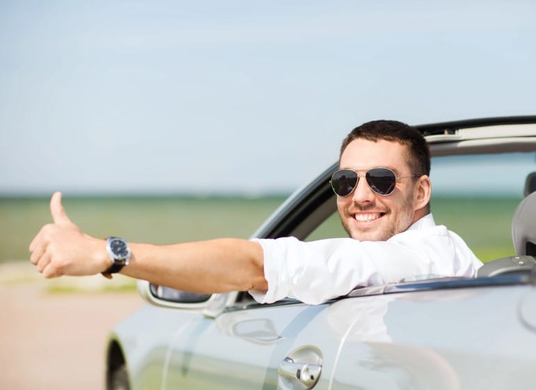 Man giving a thumbs up while driving