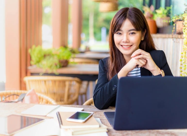 Young Asian woman outside at her laptop